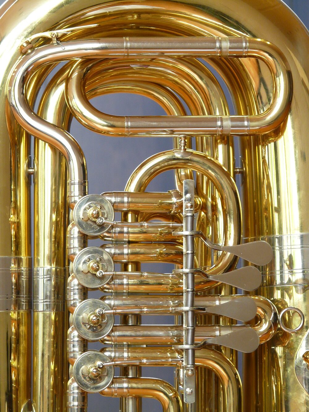 Close-up of the valves and tubing of a polished brass tuba